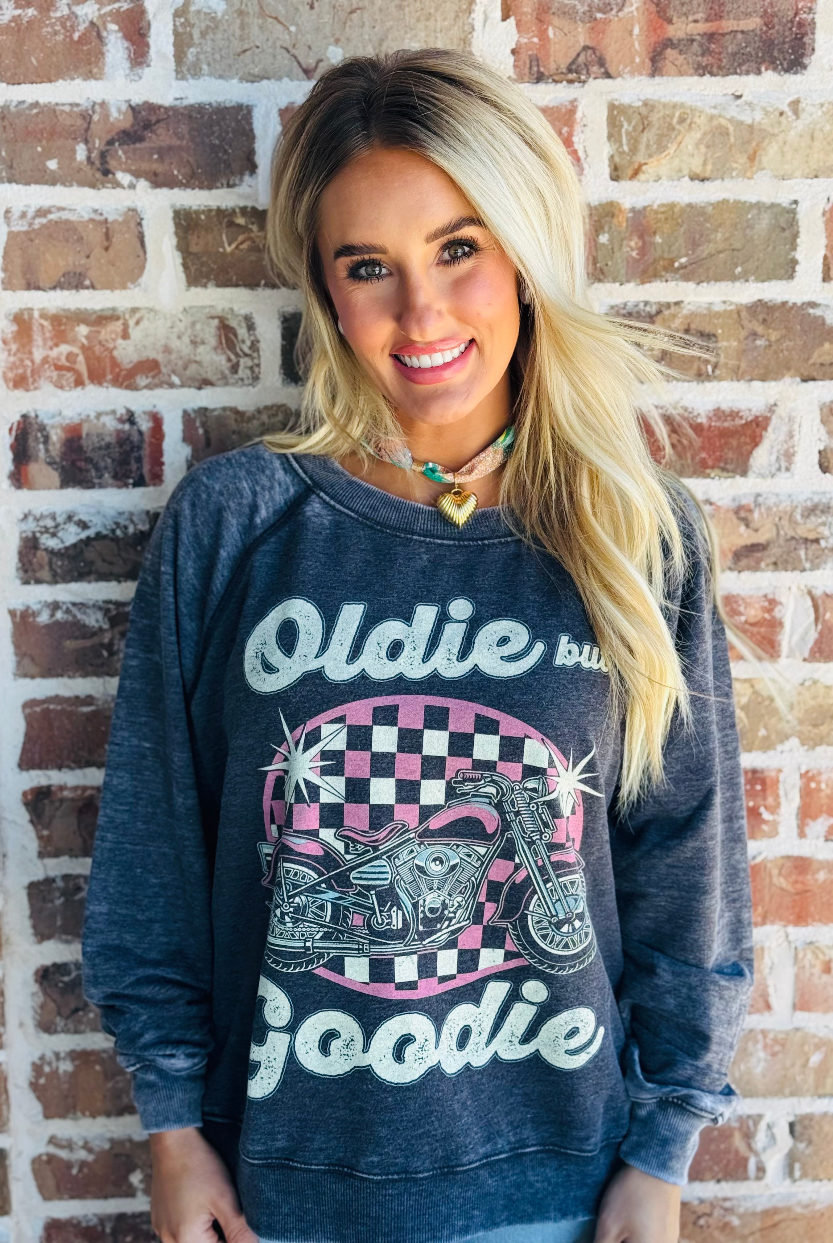 Model wearing the 'OLDIE BUT GOODIE' sweatshirt by Recycled Karma, styled in a casual, chic outfit.