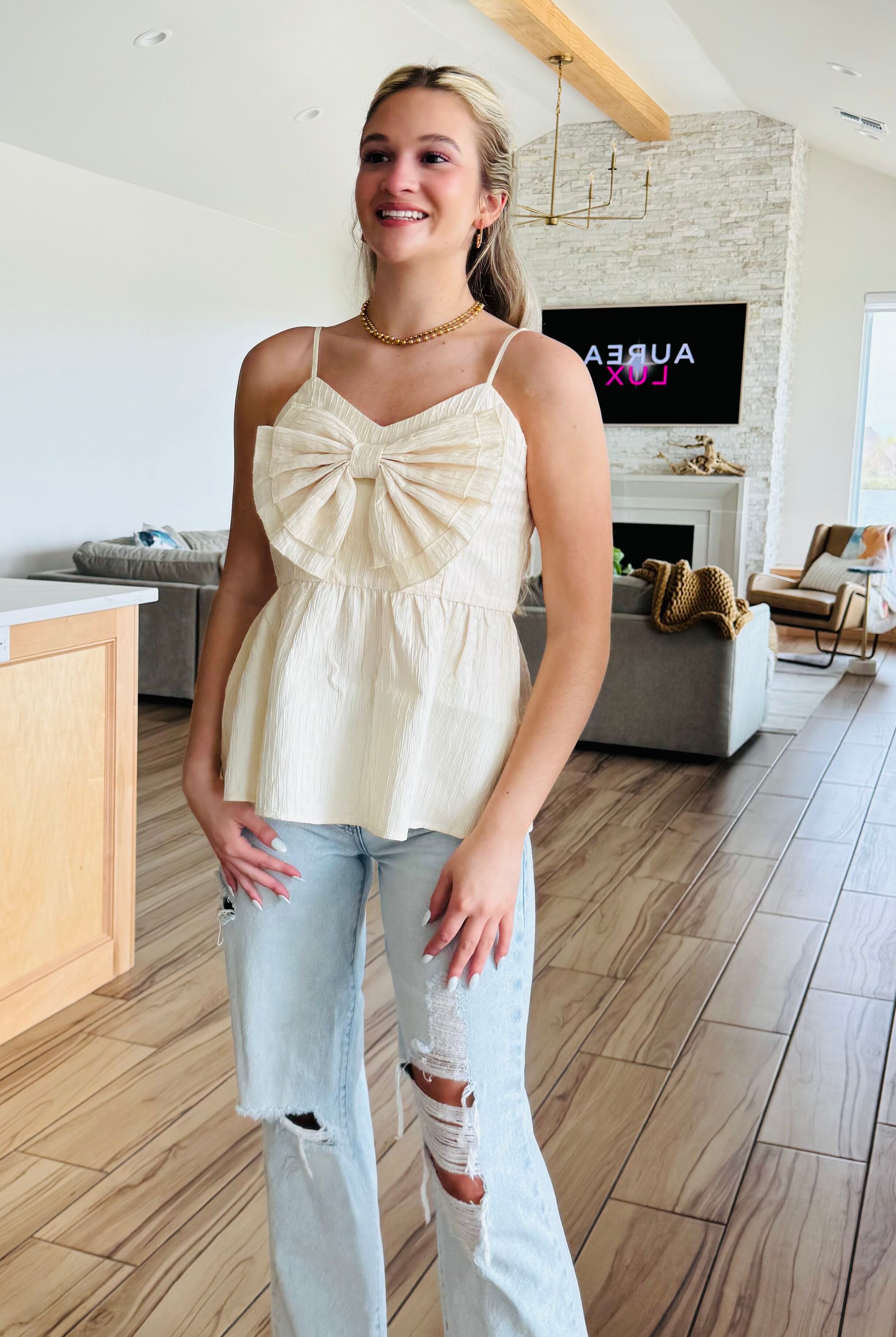ECRU BABYDOLL TEXTURED BOW TOP in a stylish setting, showcasing its flattering relaxed fit and elegant design by Heyson.