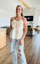 ECRU BABYDOLL TEXTURED BOW TOP in a stylish setting, showcasing its flattering relaxed fit and elegant design by Heyson.