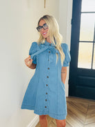 Stylish Entro denim dress with bow tie neck showcased in an outdoor setting, perfect for casual day or night attire.