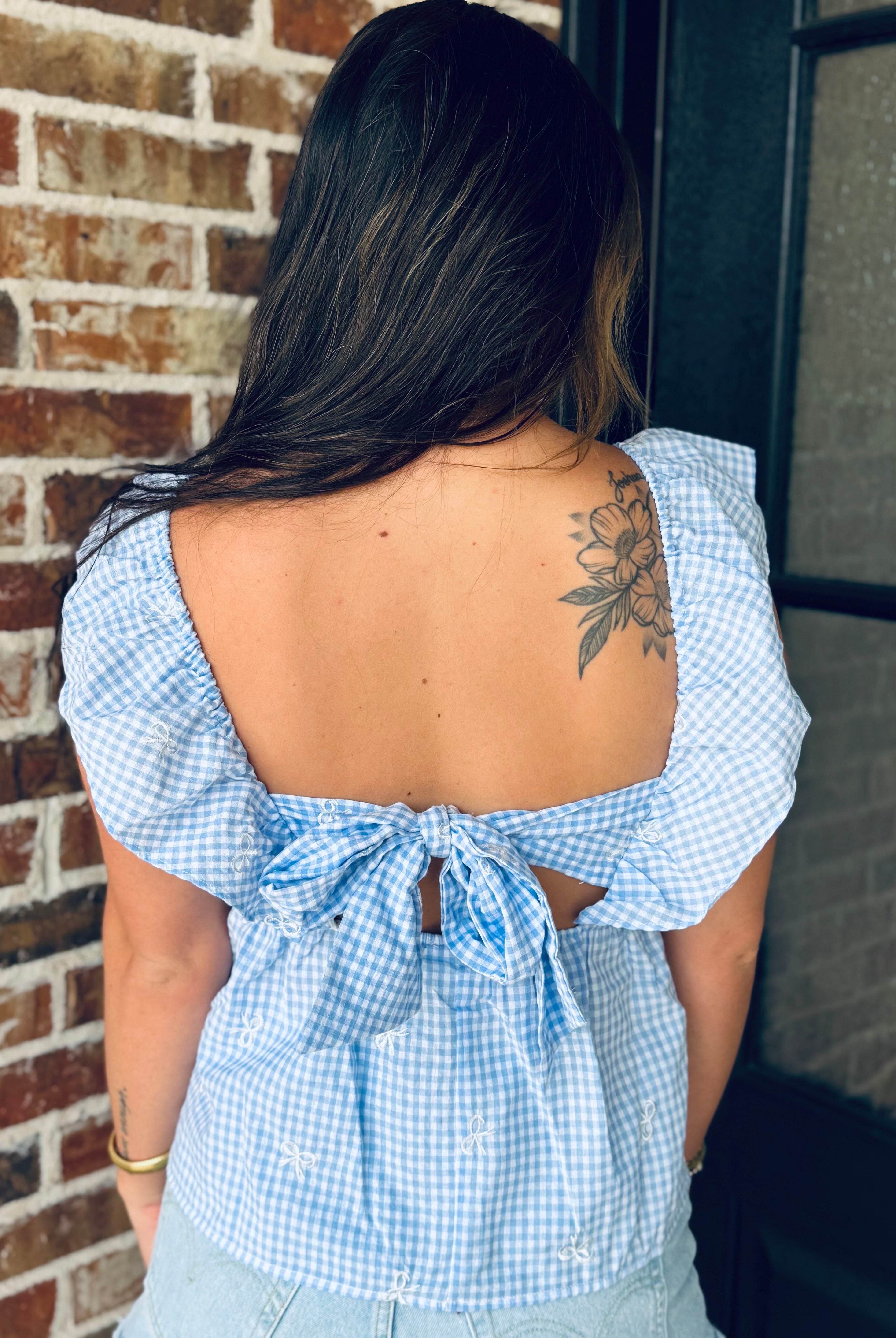 Fashion details of the Blue Gingham Bow Tie Back Top, made from lightweight woven fabric, perfect for a summer-ready wardrobe.