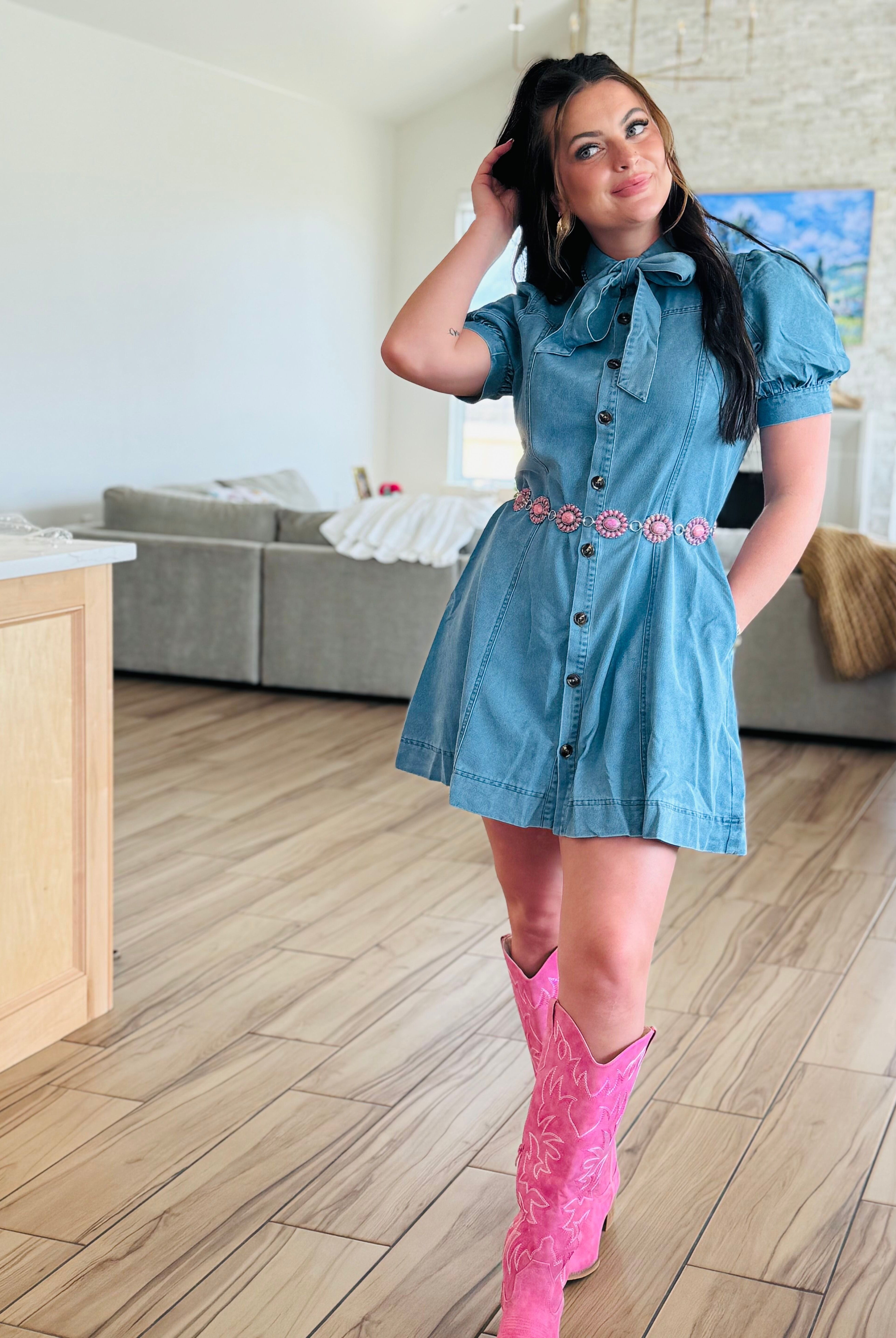 Model wearing the Entro denim dress with bow tie neck, demonstrating its versatility and flattering fit.