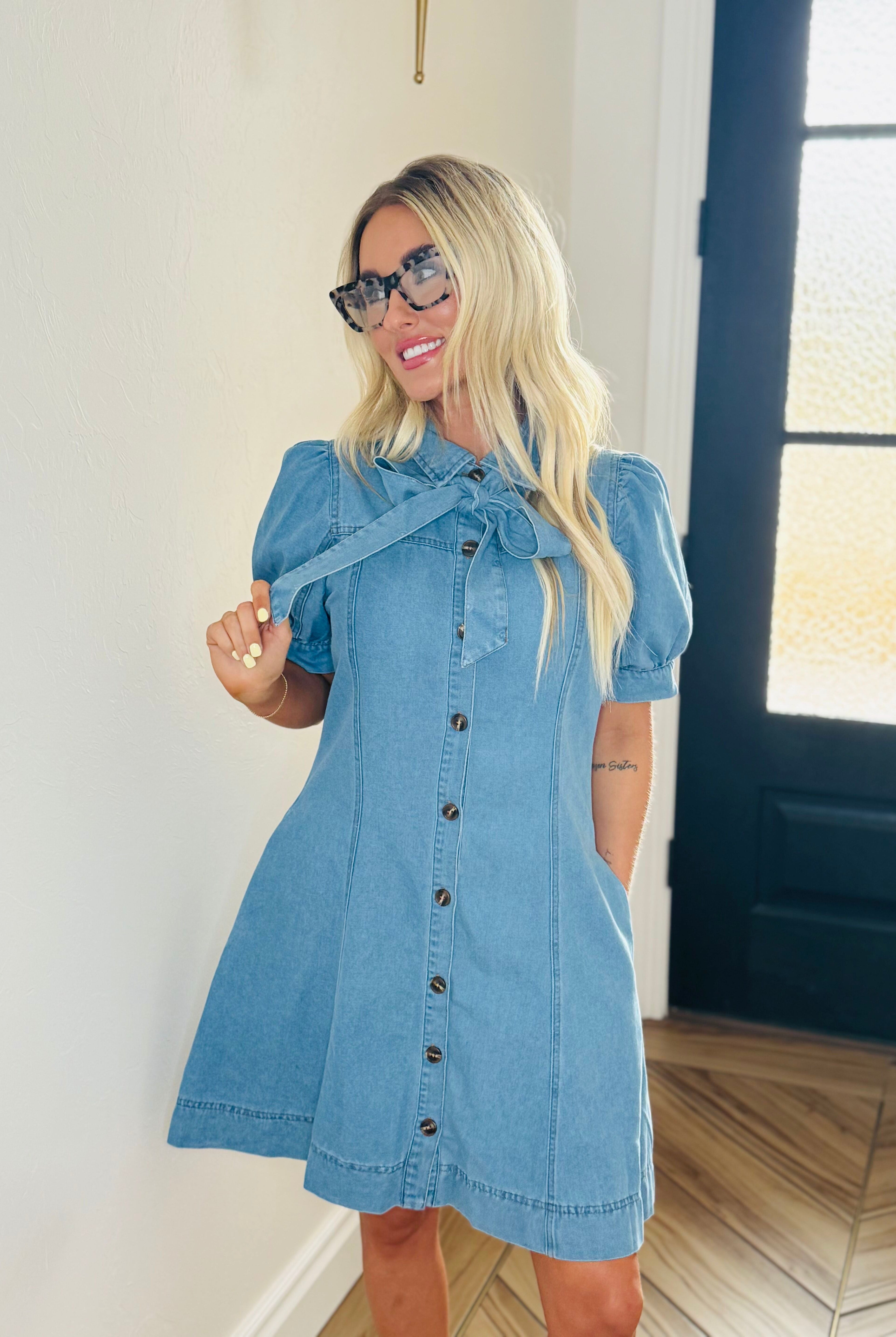 Stylish Entro denim dress with bow tie neck showcased in an outdoor setting, perfect for casual day or night attire.