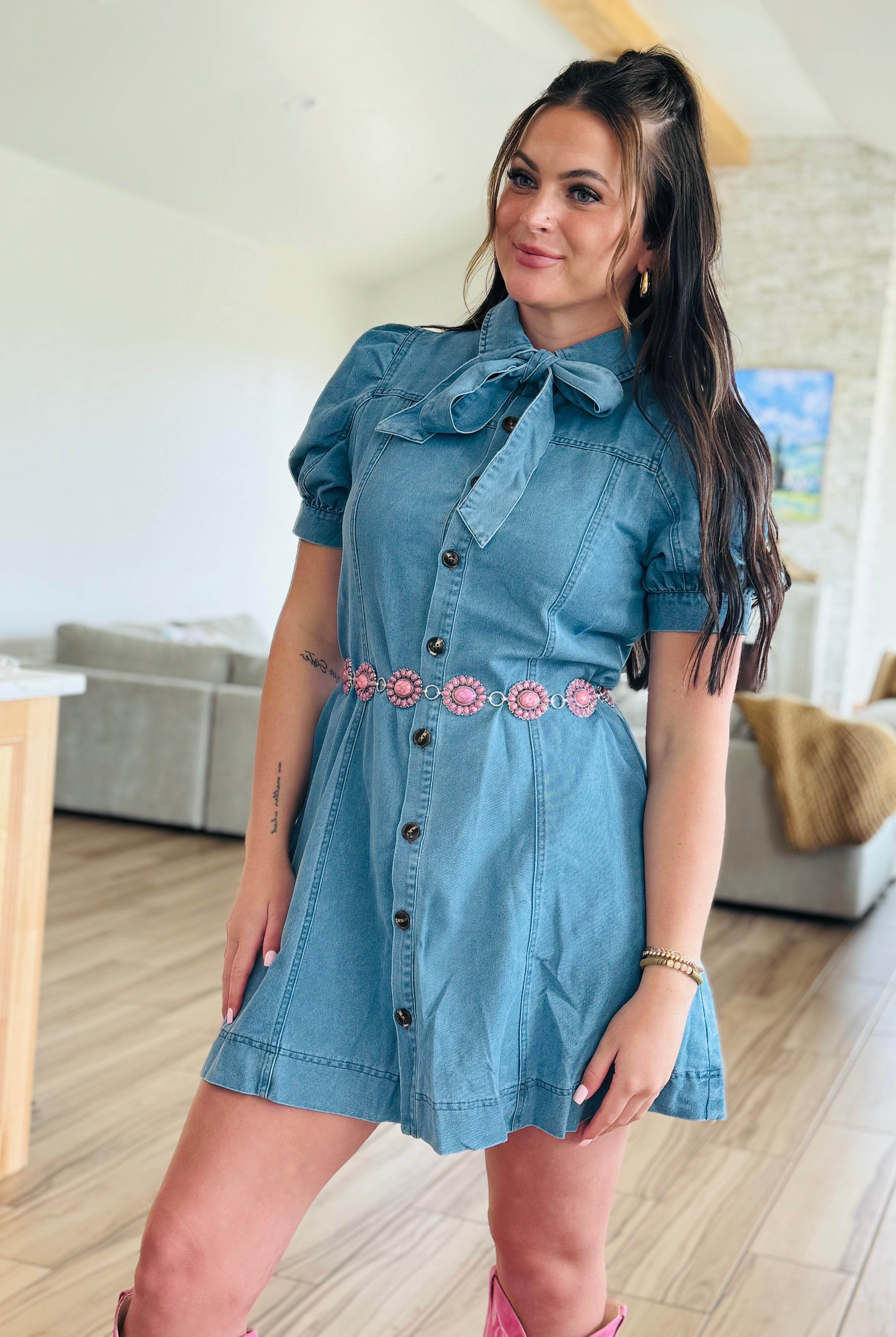 Entro denim dress with bow tie neck displayed on a hanger, showcasing the texture and design elements.