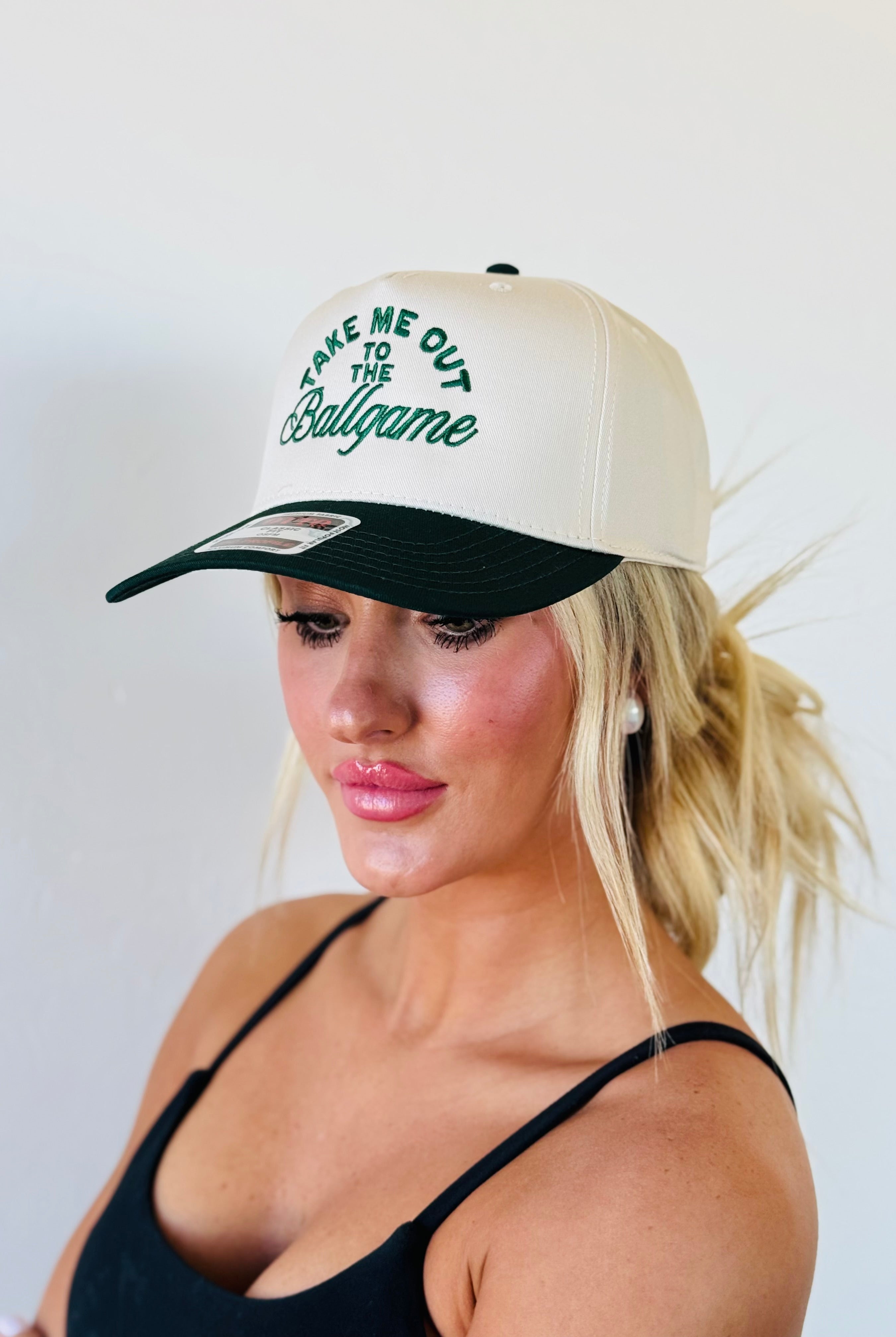 Lifestyle image of the TAKE ME OUT TO THE BALLGAME TRUCKER HAT being worn during a baseball game, showcasing its adventurous spirit.