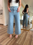 Bluebell Scallop Denim Jeans – Light Wash by ENTRO displayed stylishly in a casual setting.