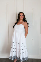 Stunning white and black embroidered maxi dress by Entro, featuring adjustable tie straps and intricate black embroidery details.