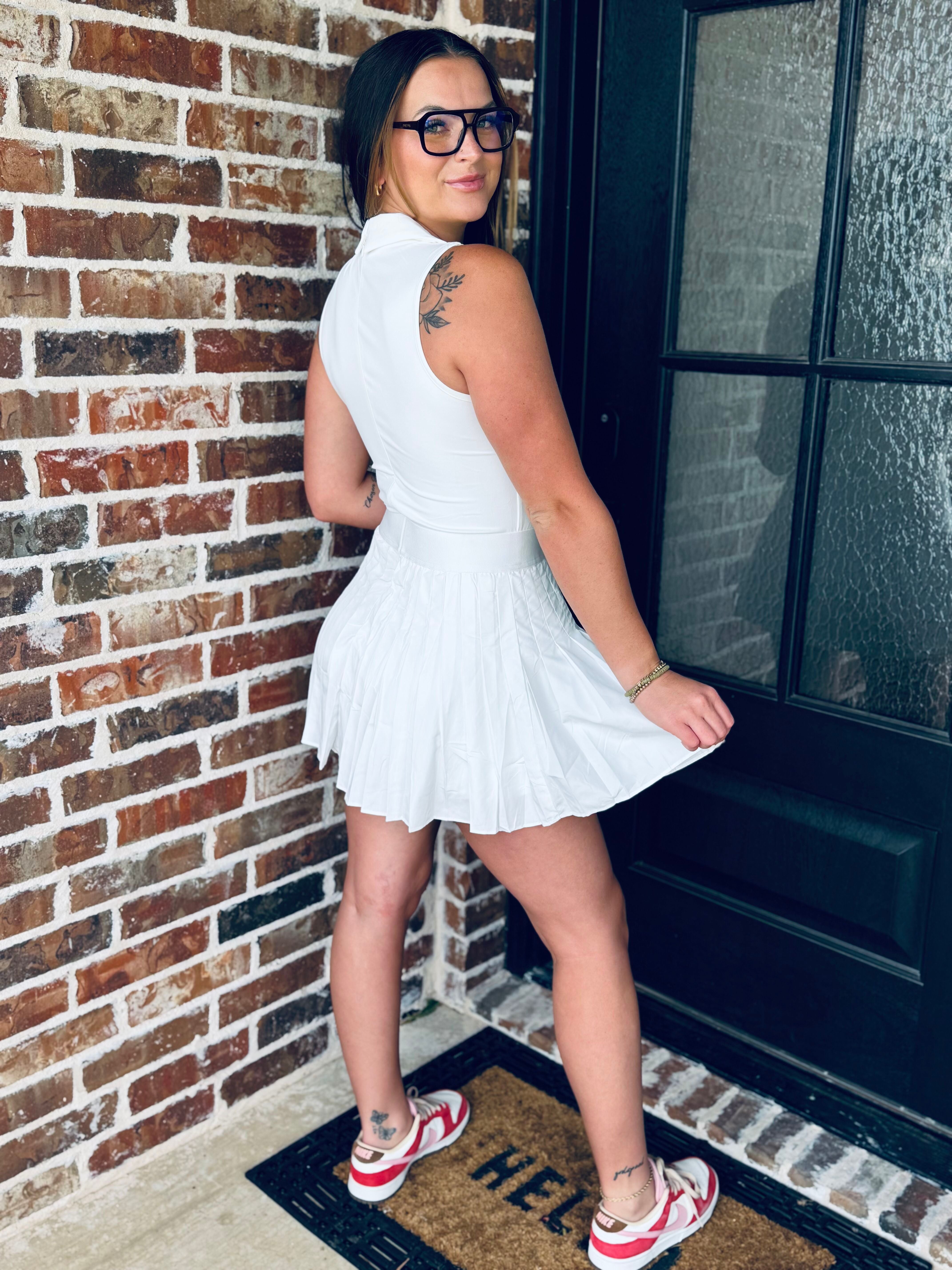 The WHITE V-NECK COLLARED ATHLETIC DRESS presented on a hanger, highlighting the lightweight, breathable fabric perfect for active lifestyles.
