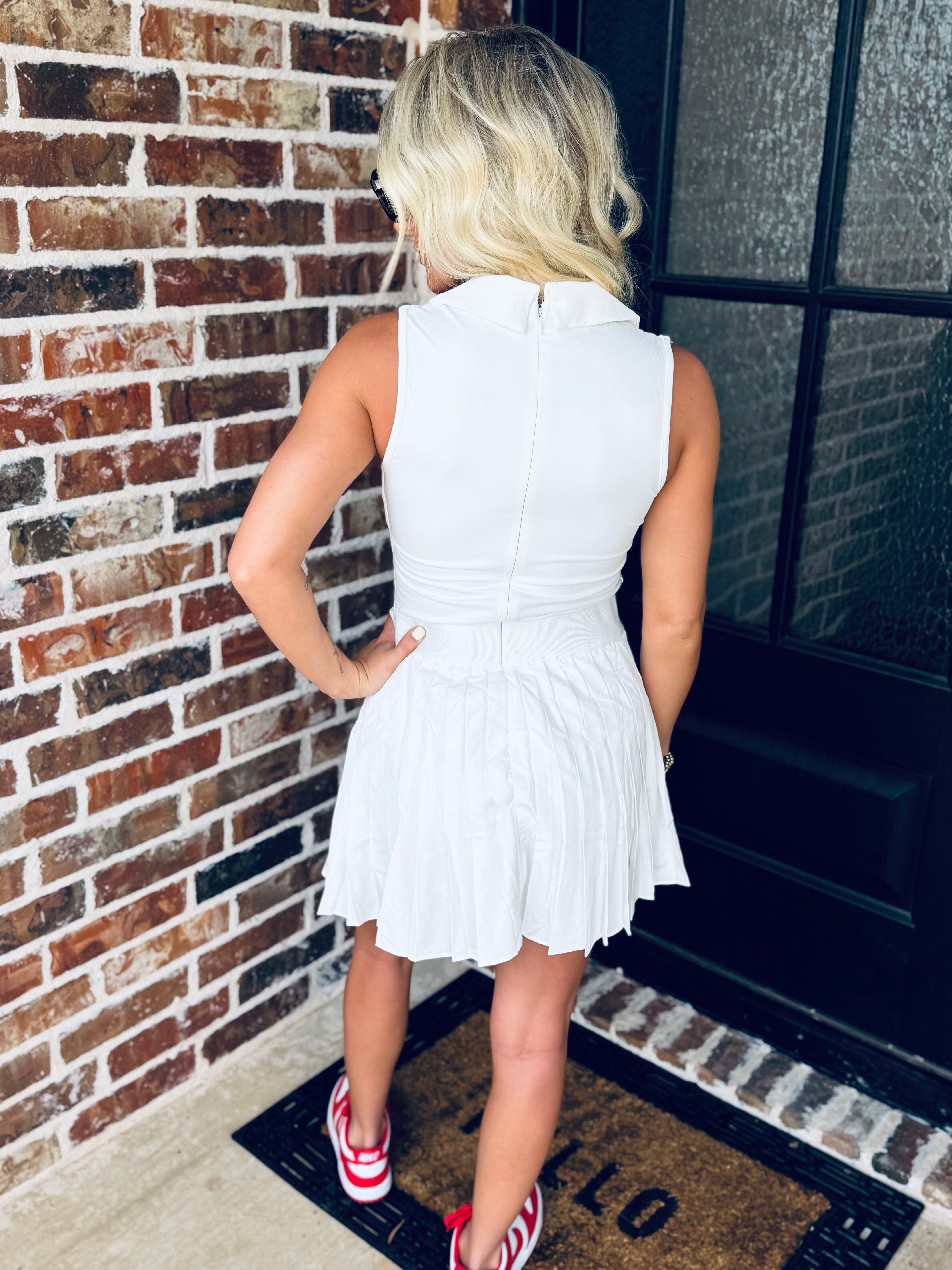 Model wearing the WHITE V-NECK COLLARED ATHLETIC DRESS in an outdoor setting, demonstrating its stylish yet functional design, suitable for varied occasions.