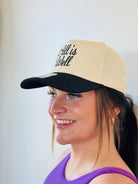 Lifestyle shot of the ALL IS WELL EMBROIDERED TRUCKER HAT being worn, demonstrating its versatility and trendy appeal.