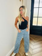 Blue Leopard Denim Jeans displayed on a hanger to emphasize the quality and design, a must-have for a standout wardrobe.