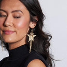 Close-up view of the GOLD SATIN ZEPPELIN EARRINGS BY NICKEL & SUEDE featuring 14k gold-filled components and a stylish design, perfect for any elegant occasion.