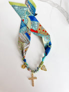 Close-up of PARIS SCARF NECKLACE featuring delicate details of the pink CZ cross, gold heart, and star pendants, ideal for enhancing any outfit.