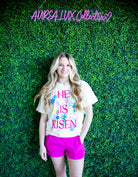 He Is Risen Tee by Poppy & Pine, featuring a bold design celebrating the resurrection of Christ, made from soft high-quality cotton.