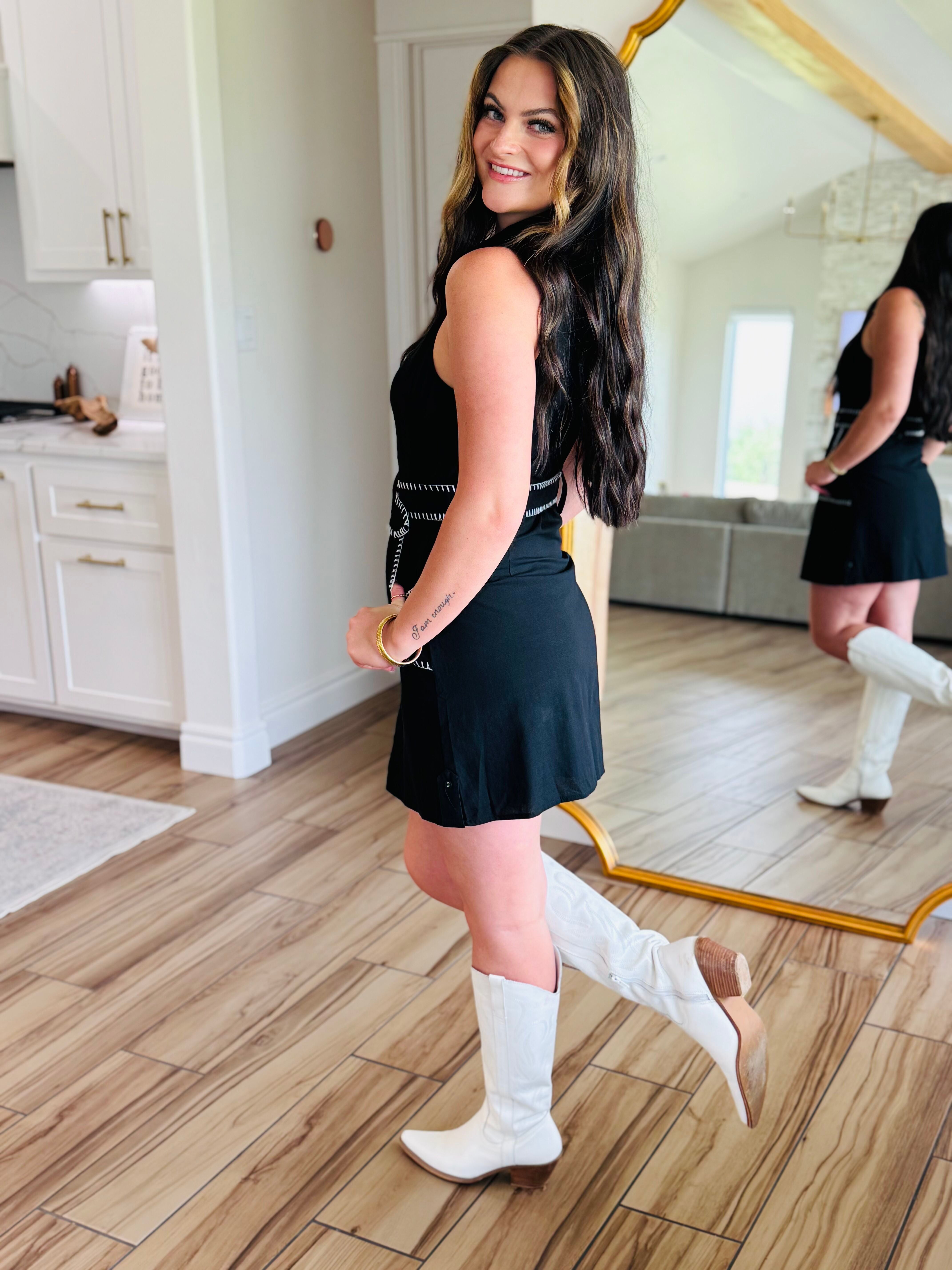 Close-up of the Black Sleeveless Dress with Contrast Stitching showing cargo pockets and removable belt, emphasizing its stylish and functional design.